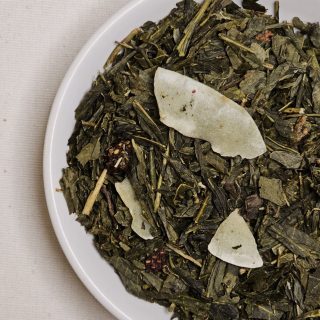 Liście herbaty Sencha Poziomkowa na talerzyku.