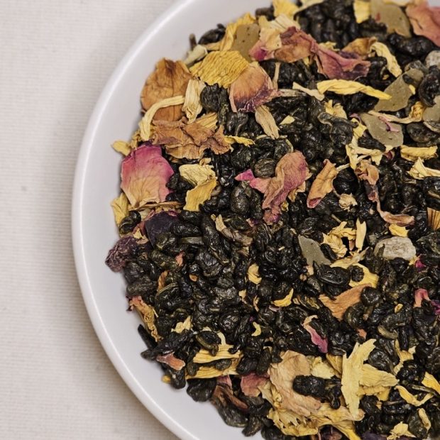 Liście herbaty Gunpowder Pasja-Mango na talerzyku.