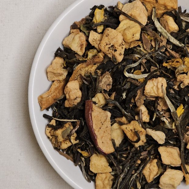 Liść białej Szarlotkowej herbaty na talerzyku.