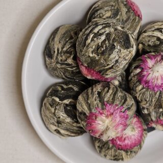 Kule herbaty Kwiat Lychee na talerzyku.