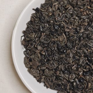 Liście Gunpowder Black na talerzyku.
