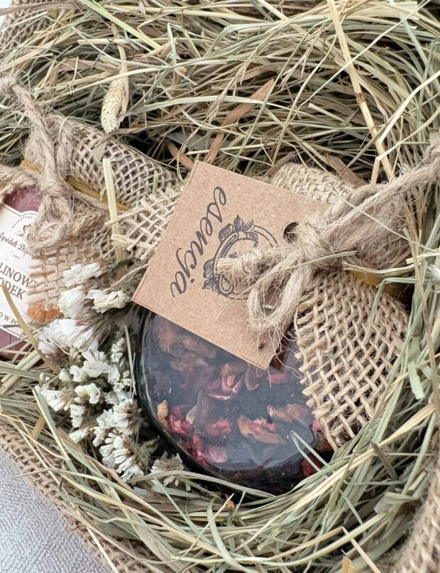 Ręcznie pakowany zestaw Malinowa Przyjemność z malinowym miodem i owocową herbatą, ozdobiony suszonymi kwiatami.