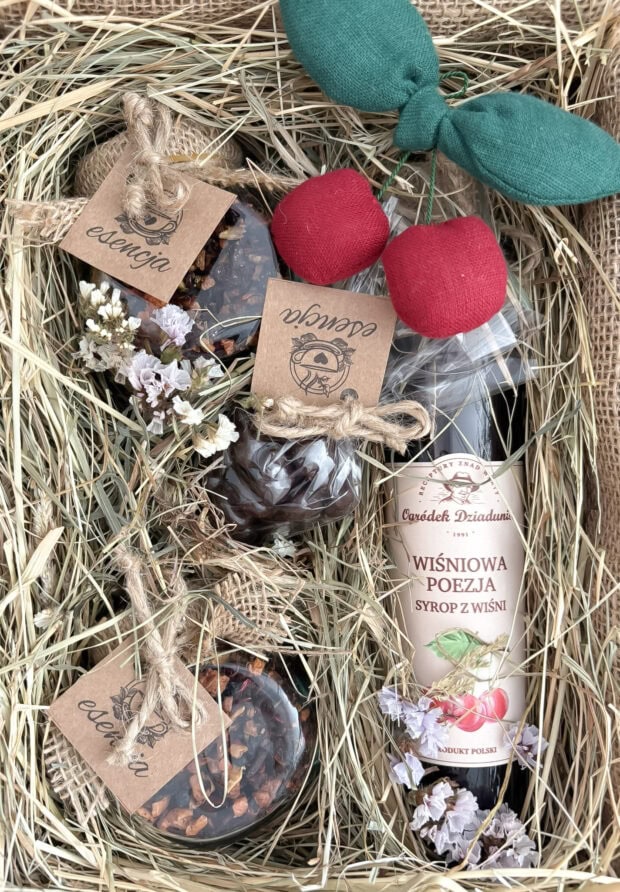 Widok z góry na zestaw Wiśniowa Słodycz – starannie ułożone produkty, dekoracje z juty i suszonych kwiatów oraz bileciki z informacjami o zawartości.