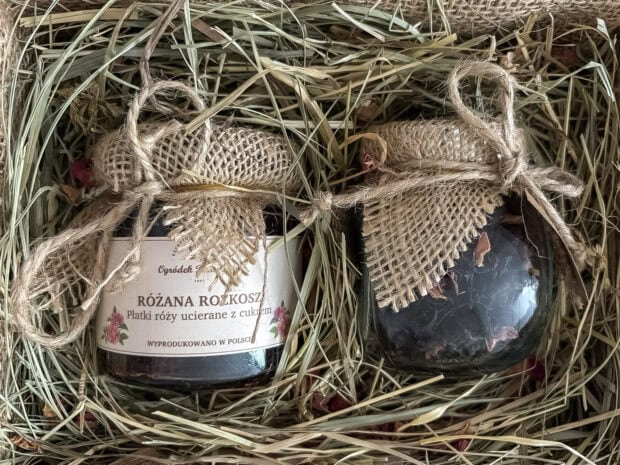 Zestaw herbaciany z różaną herbatą i płatkami róż w cukrze, zapakowany w jutę i celofan.