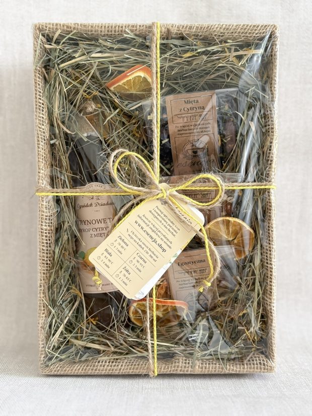 Box prezentowy z syropem i herbatami, zapakowany w pudełko i celofan, przewiązane sznurkiem.