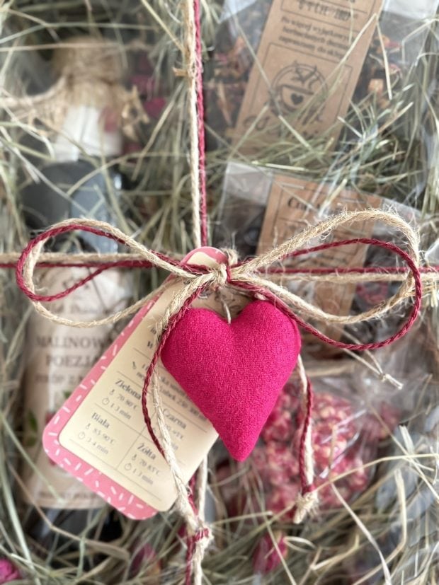 Box prezentowy Słodka Malina z syropem malinowym, herbatami i delikatesami zamkniętymi w pięknym, naturalnym pudełku, ozdobione szytym serduszkiem.