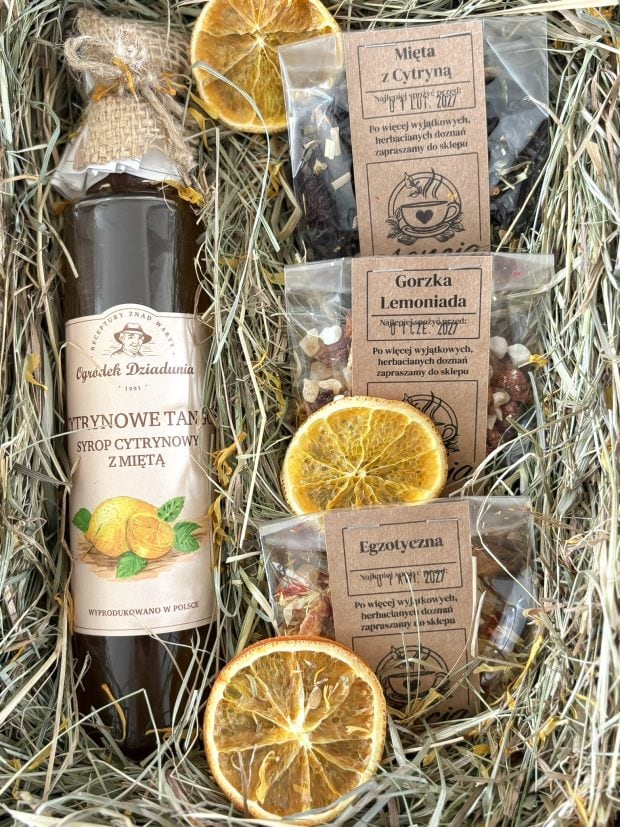 Box wyścielony naturalnym siankiem, a w nim syrop i herbaty.