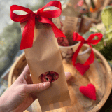 Maliny w białej czekoladzie w szarym opakowaniu, ozdobione kokardą