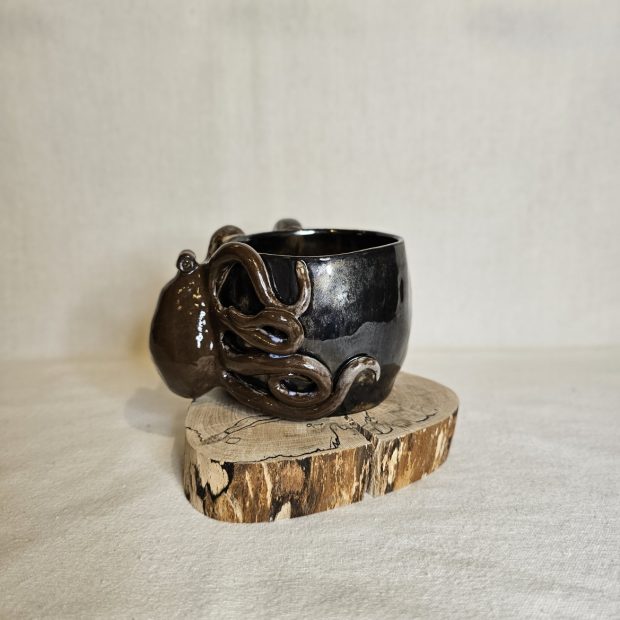 Zaprezentowany bok kubka z ośmiornicą w czekoladowym kolorze.