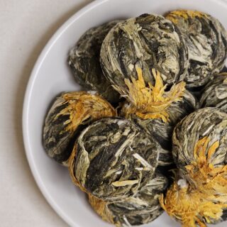 Kule herbaty Kwiat Brzoskwini na talerzyku.