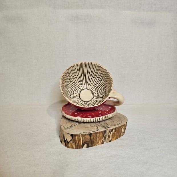 Środek filiżanki w kształcie muchomora na pieńku.