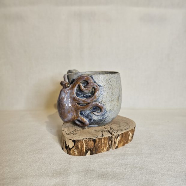 Profil kubka z ośmiornicą na pieńku.