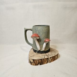 Kufel z muchomorami przymocowanymi do frontu, całość rękodzieło z gliny.