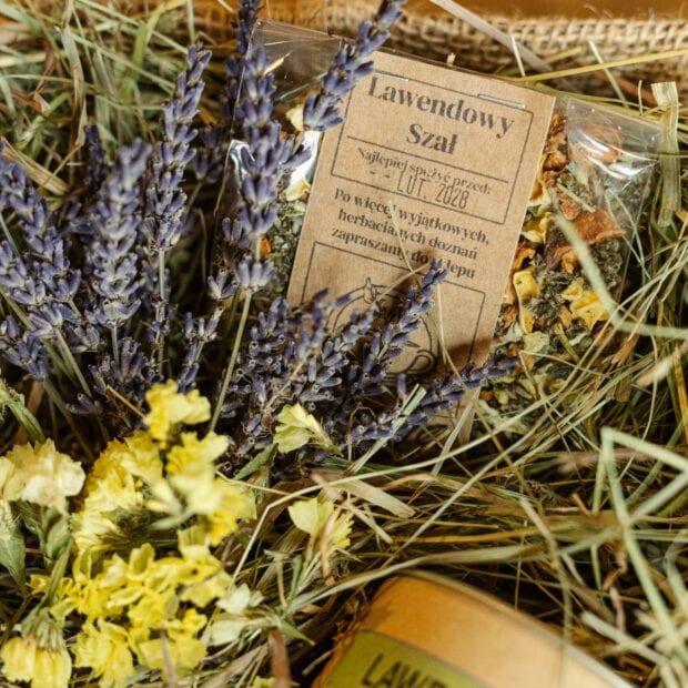 Biała herbata Lawendowe Pole w transparentnej torebce w otoczeniu naturalnych dekoracji - sianka i kwiatów.